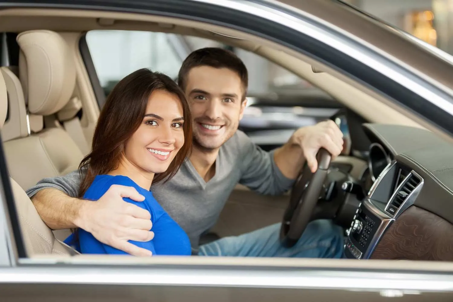 Couple smiling in the front seats of their insured car