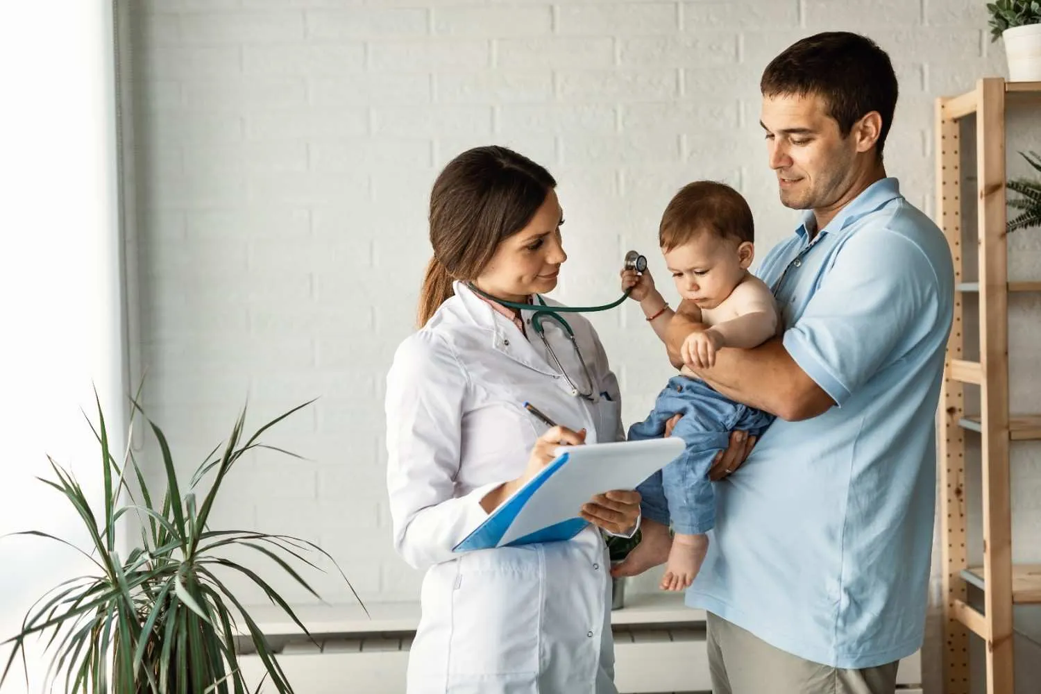 Nurse checking a baby held by a parent during a health visit