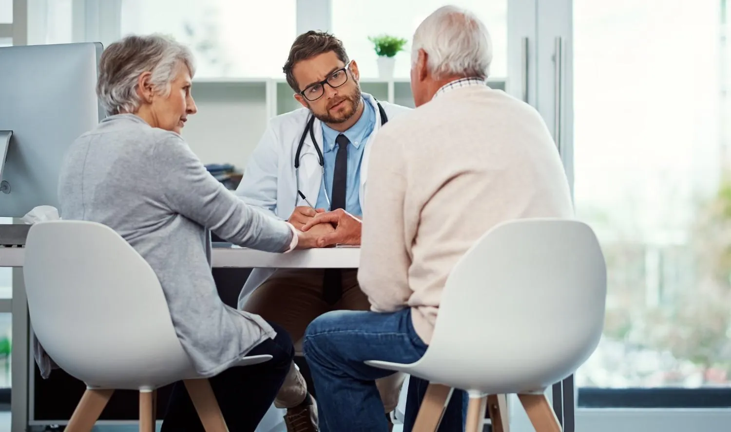 Doctor talking with an older couple about their Medicare options