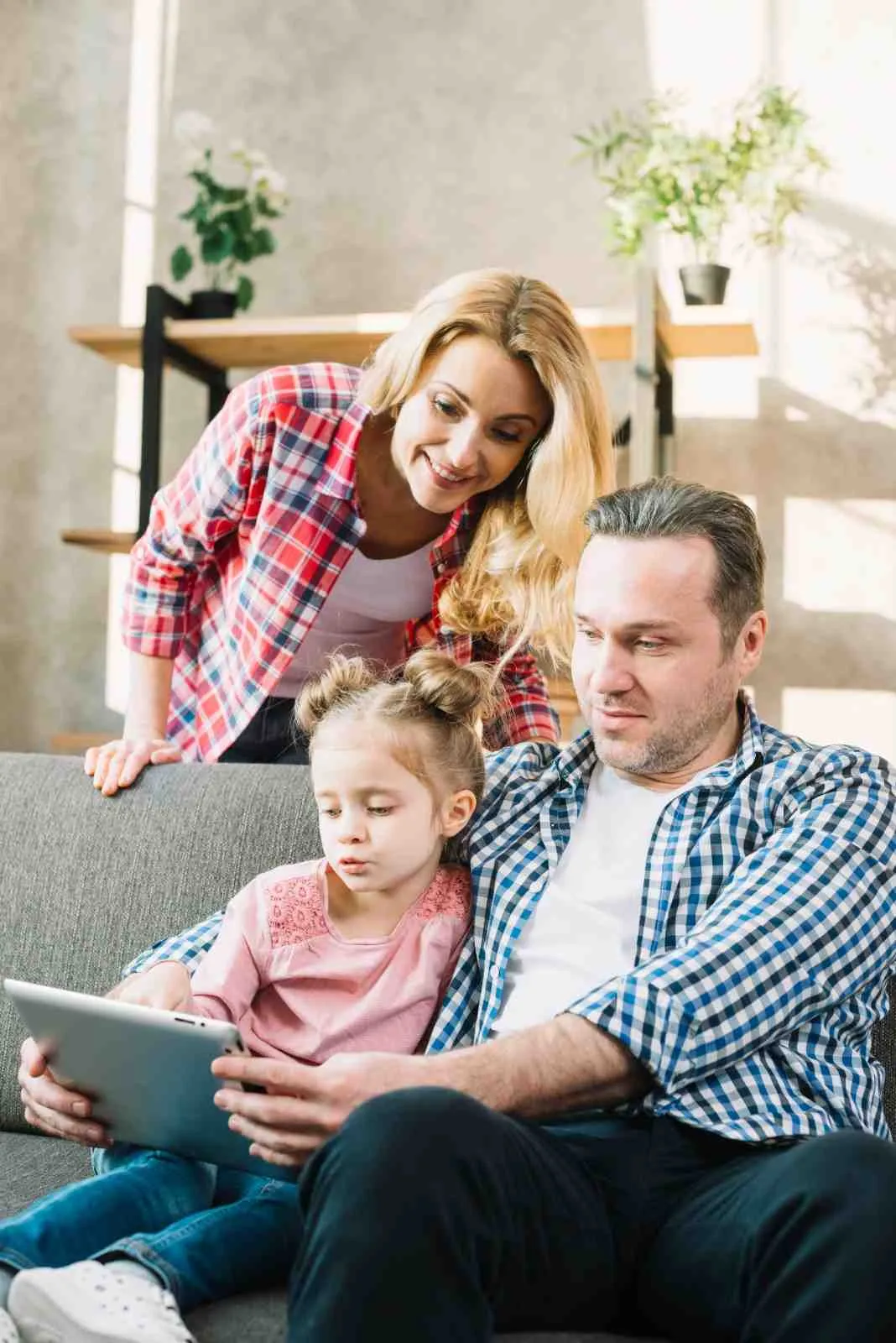 Family relaxing at home on the sofa with a tablet